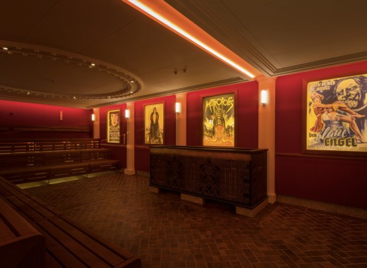 Sauna mit Ofen und Filmplakaten an den roten Wänden