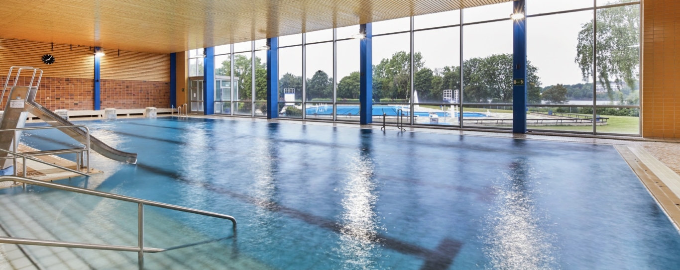 Schwimmbad mit Bahnen und Fensterfront