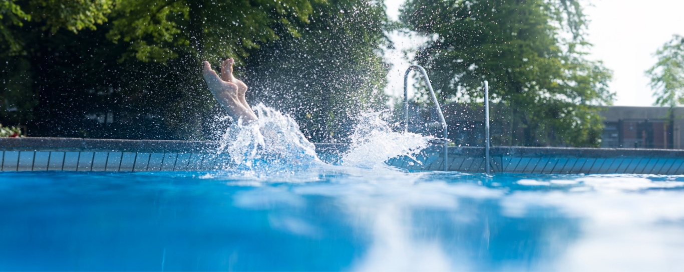 Füße tauchen ins Wasser ein.