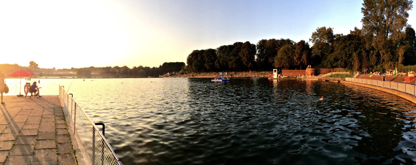 Stadtparksee mit Ufer und Sonnenuntergang.