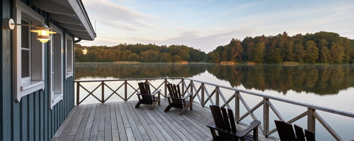 Saunaveranda mit Stühlen und Blick auf einen See