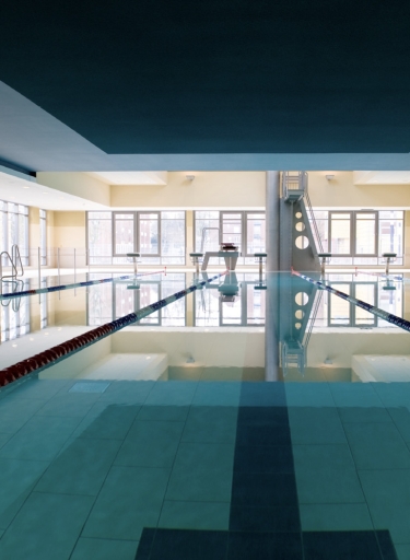 Schwimmbad mit hellen Wänden, Fensterfront und dunkler Decke