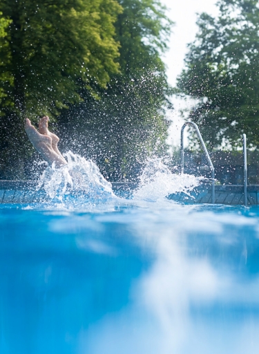 Füße tauchen ins Wasser ein.