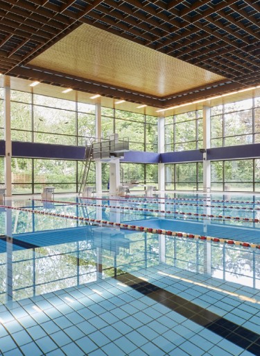 Schwimmbad mit Glasfassade und Sprungturm