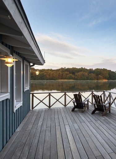 Saunaveranda mit Stühlen und Blick auf einen See