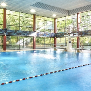 Schwimmbad mit Bahnen, Fensterfront und Lichtern an der Decke