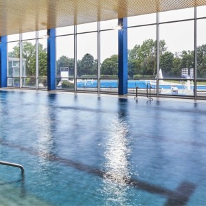 Schwimmbad mit Bahnen und Fensterfront