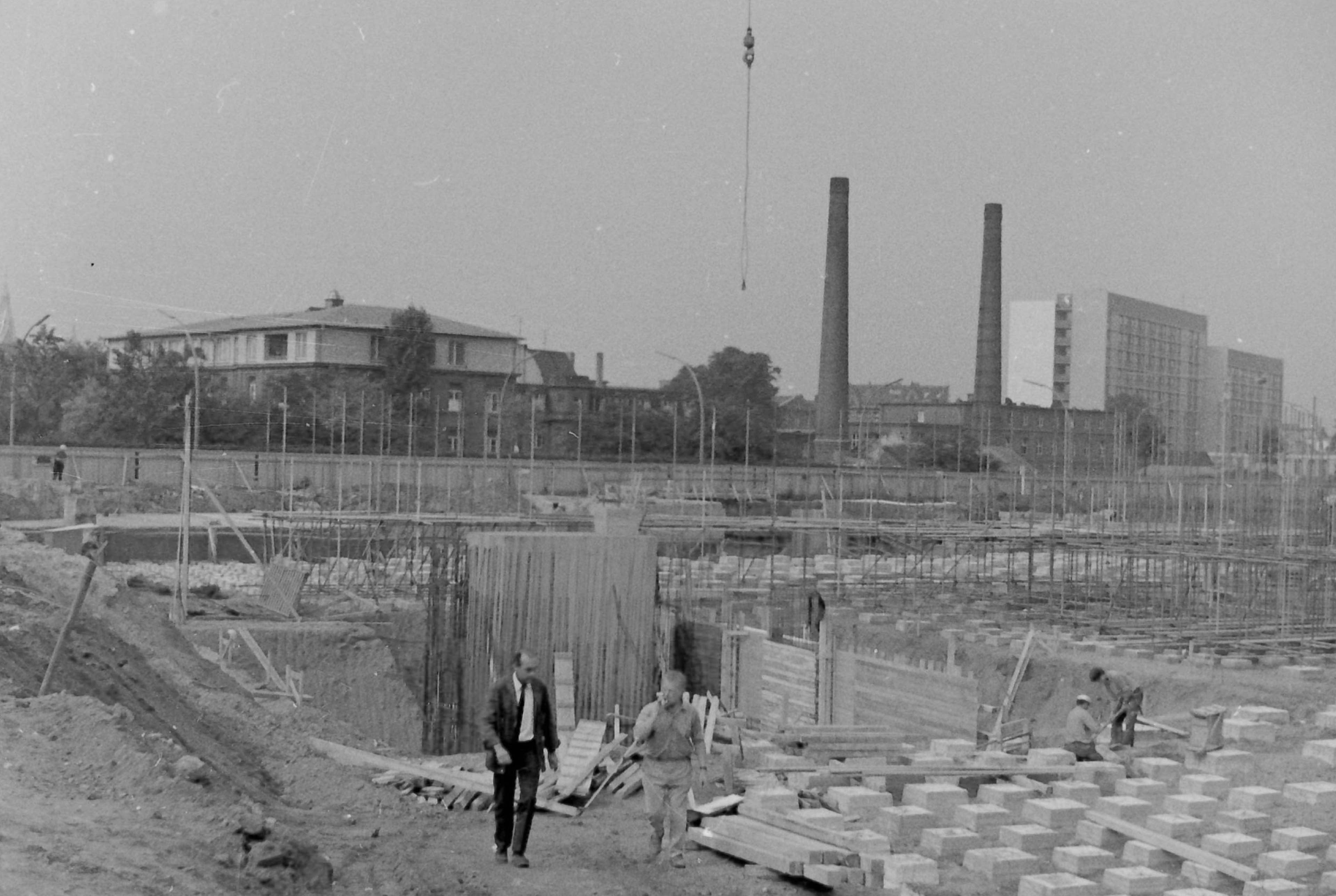 Die Fundamentlegung für den 10-Meter-Sprungturm – im Hintergrund ragen der Bunker und die beiden Schornsteine der Asklepios Klinik St. Georg aus dem Boden.