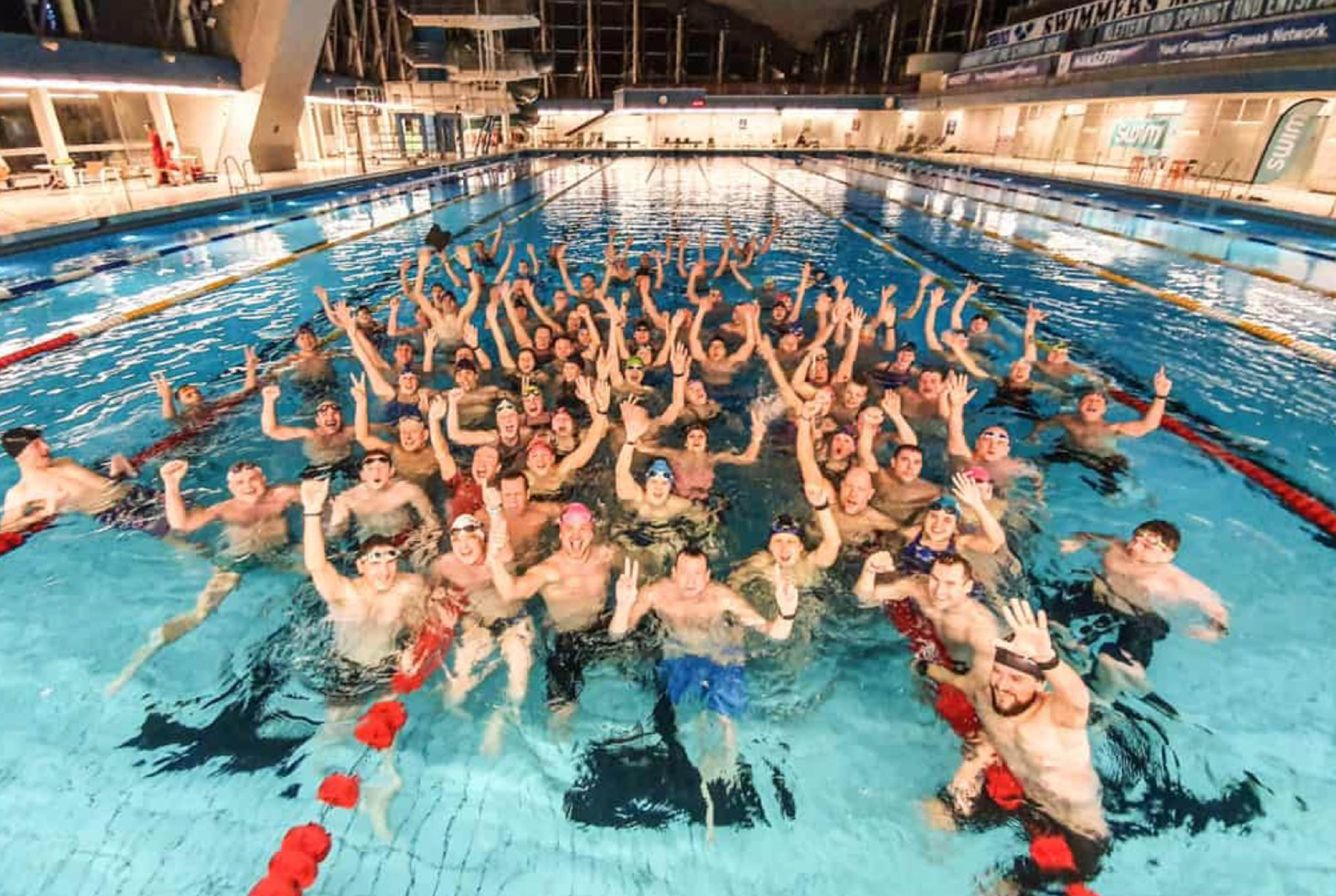 Gruppe von Menschen im Schwimmbecken jubeln