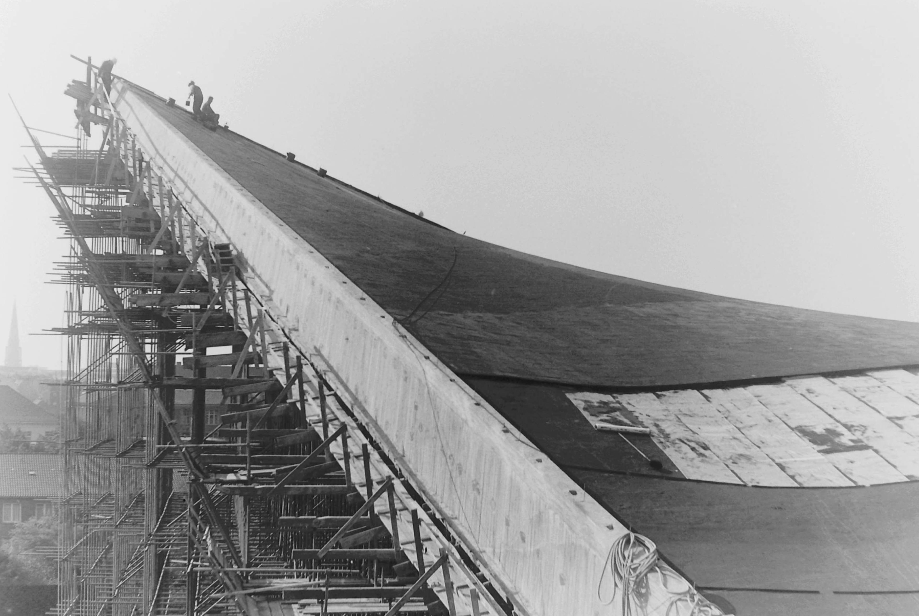 Blick auf Bauarbeiter die an der Spitze eines Daches arbeiten