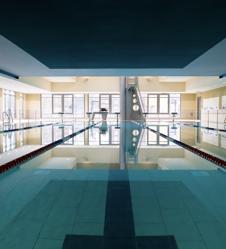 Schwimmbad mit hellen Wänden, Fensterfront und dunkler Decke