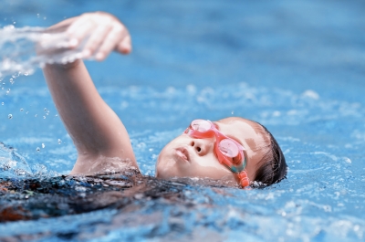 Mädchen mit orangefarbener Schwimmbrille krault