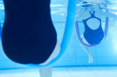 Zwei Frauen in Schwimmnudeln sitzend unter Wasser